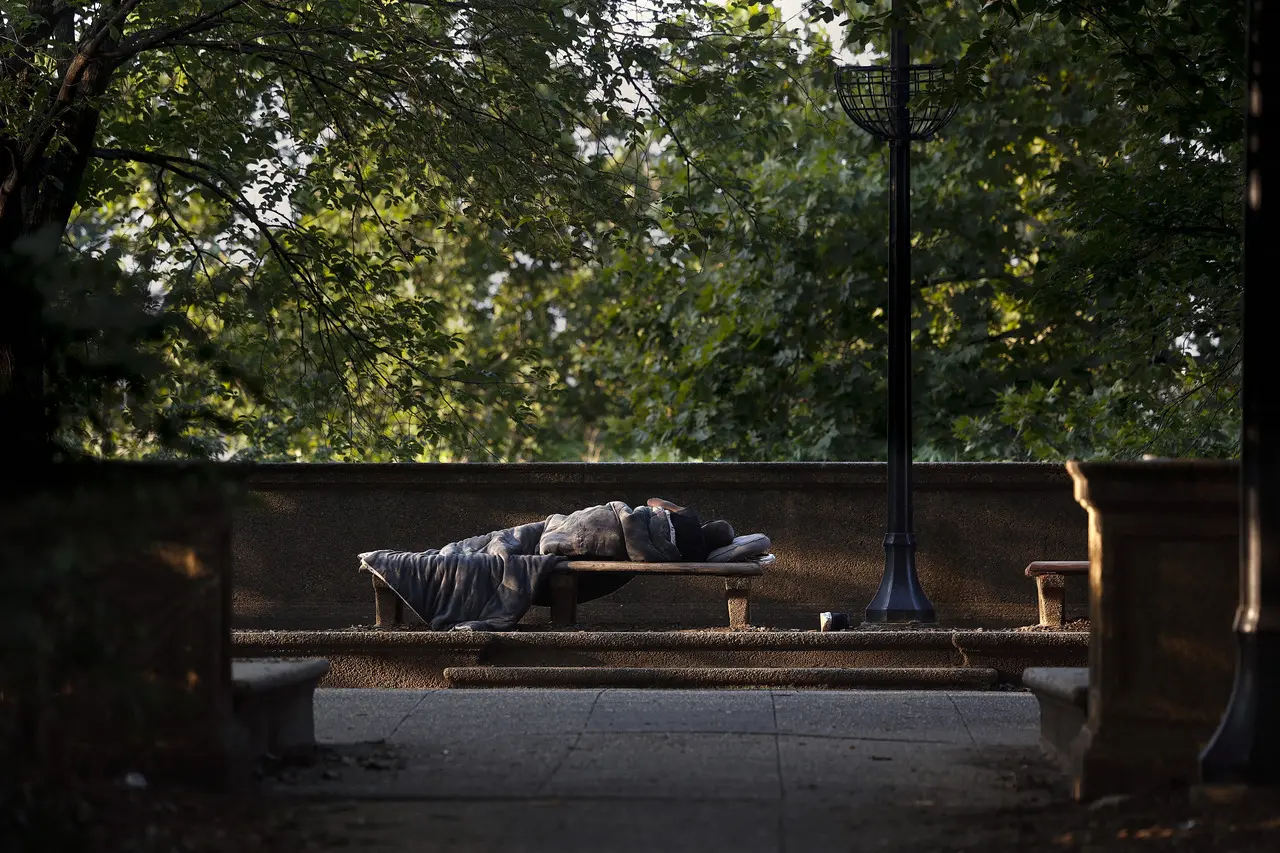 Imagem mostra pessoa em situação de rua dormindo em banco de praça em Washington, nos Estados Unidos, ilustrando fala de Trump que pediu às pessoas sem teto para deixar Washington.
