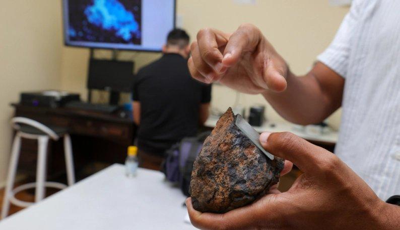 Imagem mostra mão segurando uma pedra onde há o cobalto no que parece ser um laboratório. Imagem usada em matéria sobre a primeira mina de diamentes no Ceará. Fim da descrição