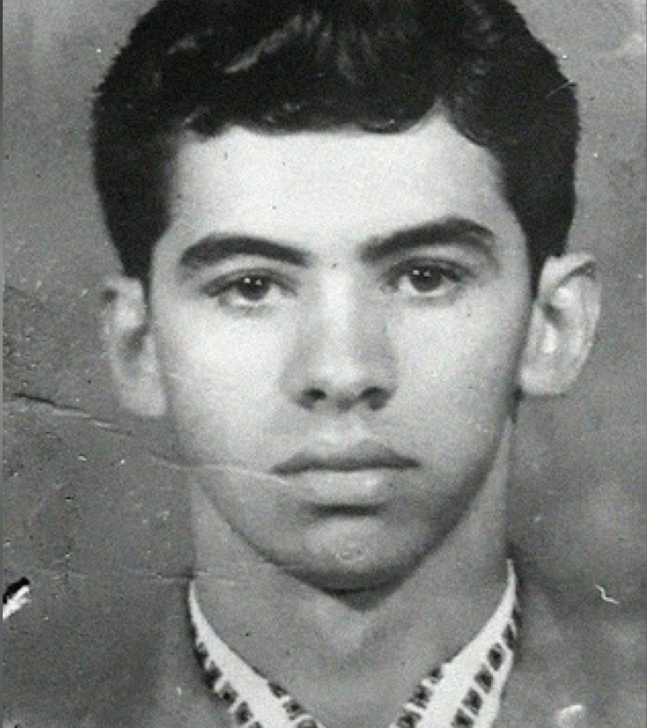Foto em preto e branco do jovem João Nogueira Jucá, de frente para a câmera. Ele tem cabelo escuro, curto e penteado para o lado. Suas sobrancelhas são grossas e escuras. Ele está vestindo um paletó escuro sobre uma camisa clara com um padrão na gola. A expressão em seu rosto é séria.