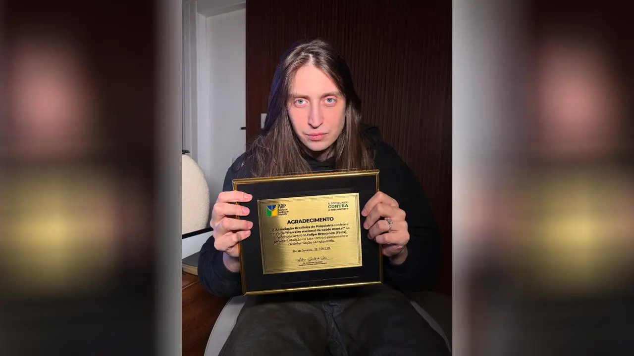 Felca segurando placa com o título de parceiro da saúde mental da associação brasileira de psiquiatria