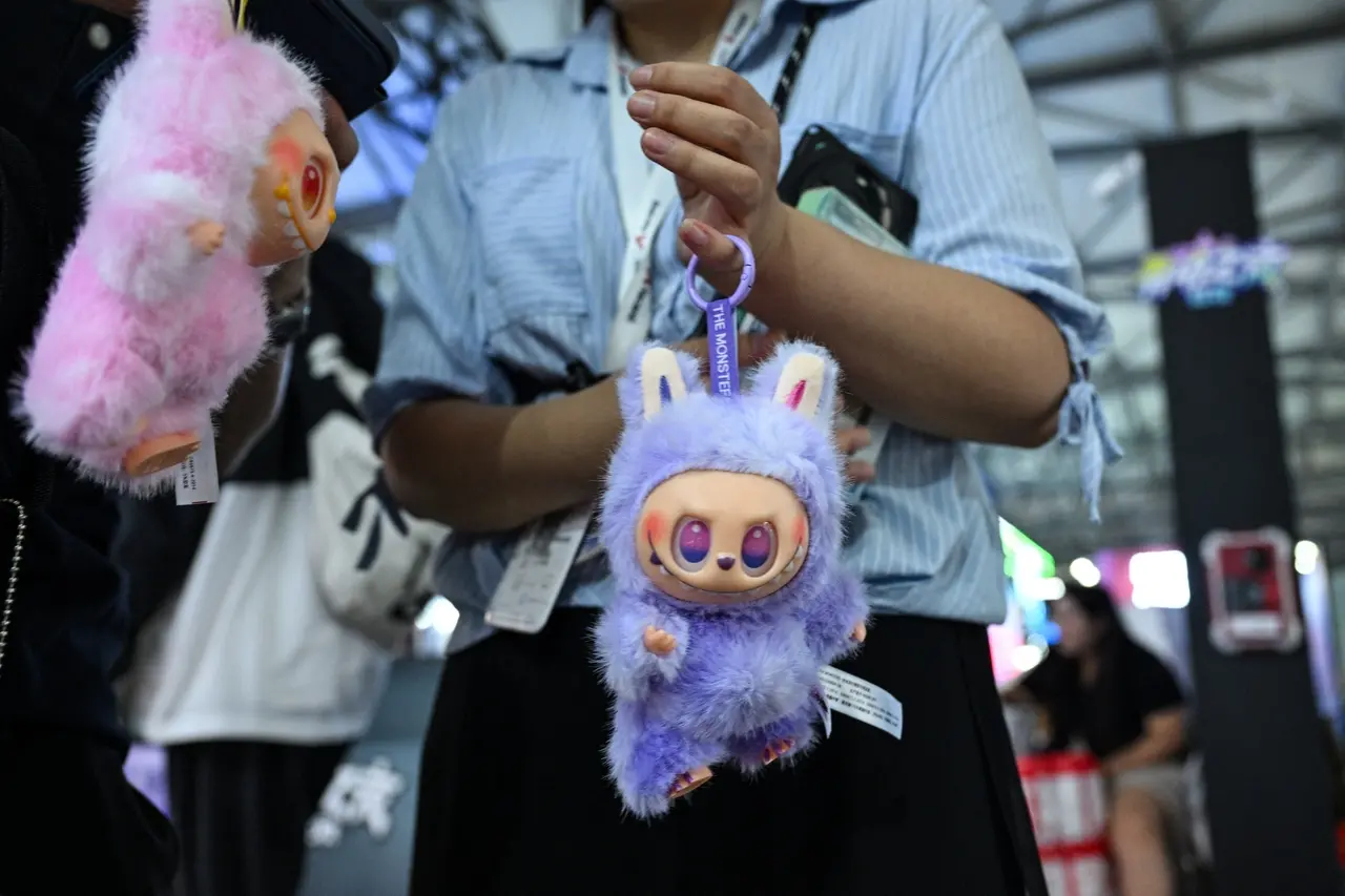 Imagem mostra uma mulher vende brinquedos de pelúcia Labubu para os visitantes durante, ilustrando crescimento no lucro da Pop Mart devido à boneca