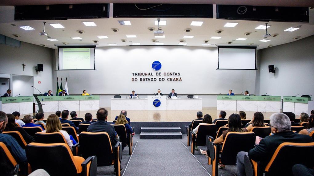 Sessão no plenário do Tribunal de Contas do Estado do Ceará, com conselheiros na mesa diretora e público acompanhando nas cadeiras do auditório.
