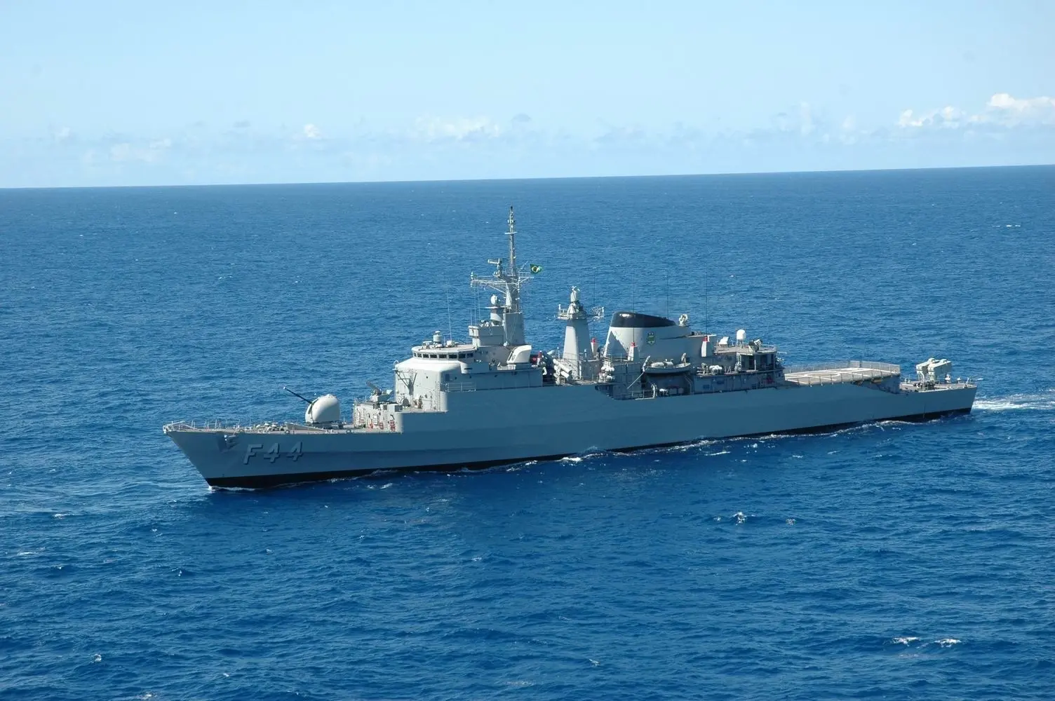 Navio de guerra navegando pelo oceano, equipado com sistemas militares e armamentos, simbolizando presença naval e poder marítimo.