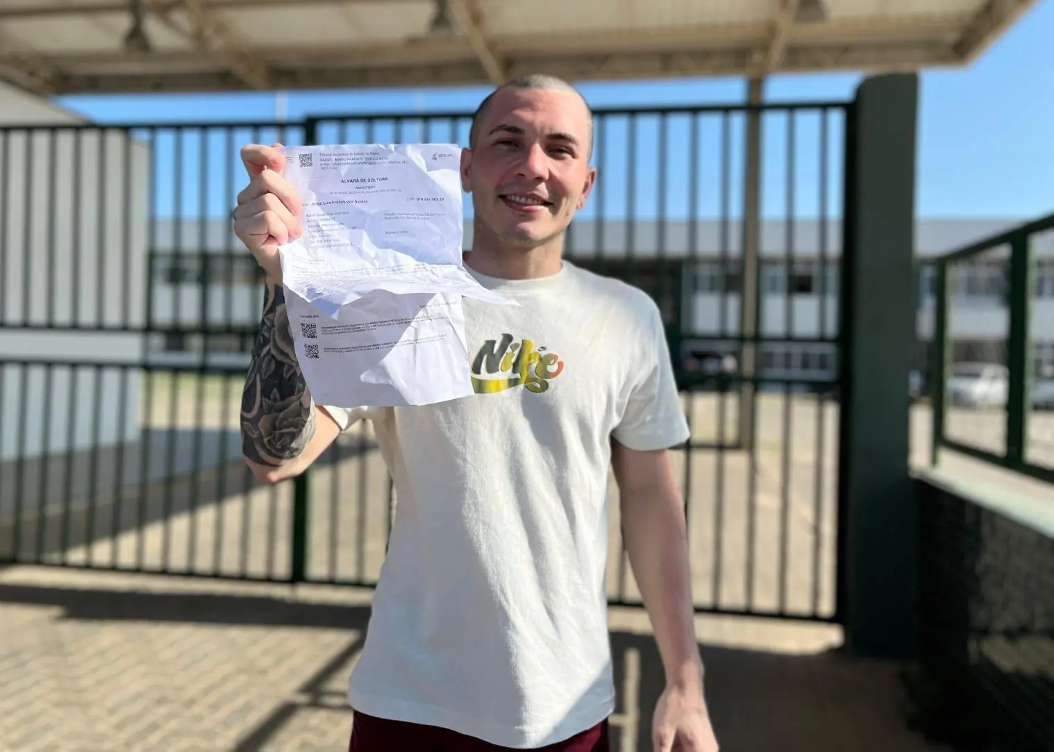 Jorge Luiz, motoboy que foi absolvido do crime de estupro, segura seu alvará de soltura em frente à prisão