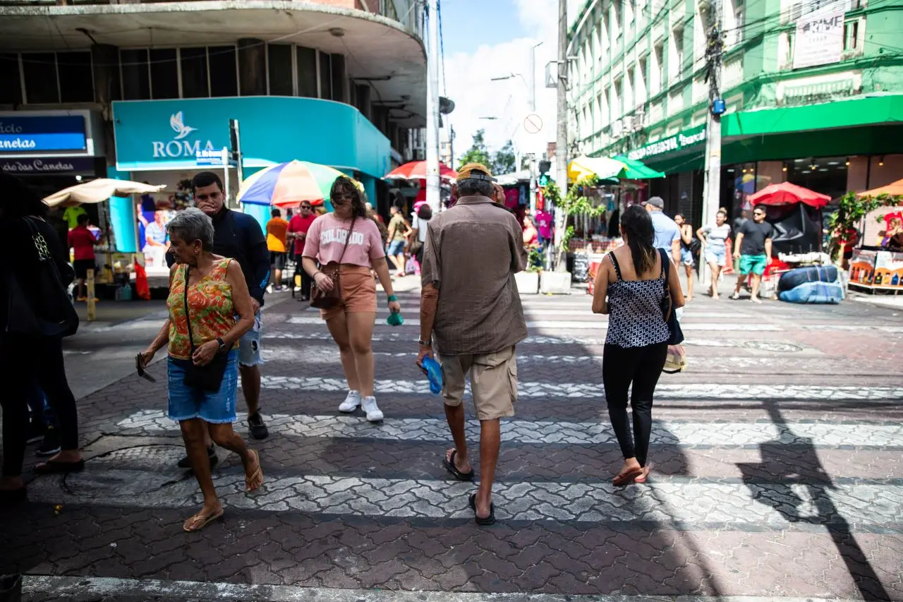 pessoas atravessando rua em faixa de pedestre, em fortaleza. cidade tem mais de 2,5 milhões de habitantes