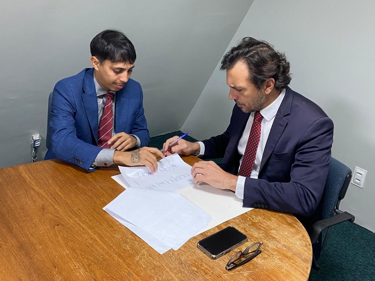 Foto mostra os deputados estaduais Léo Suricate e Guilherme Sampaio durante a subscrição à PEC da internet por parte do líder do Governo Elmano