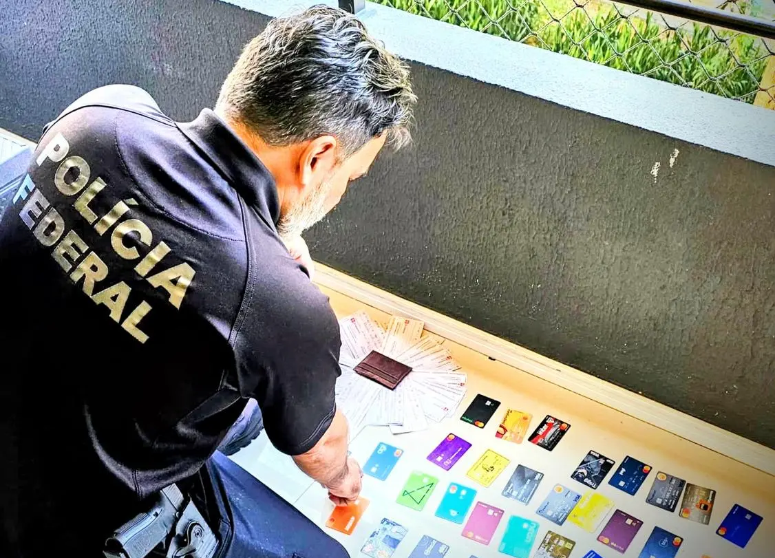Agente da PF com cartões apreendidos no chão