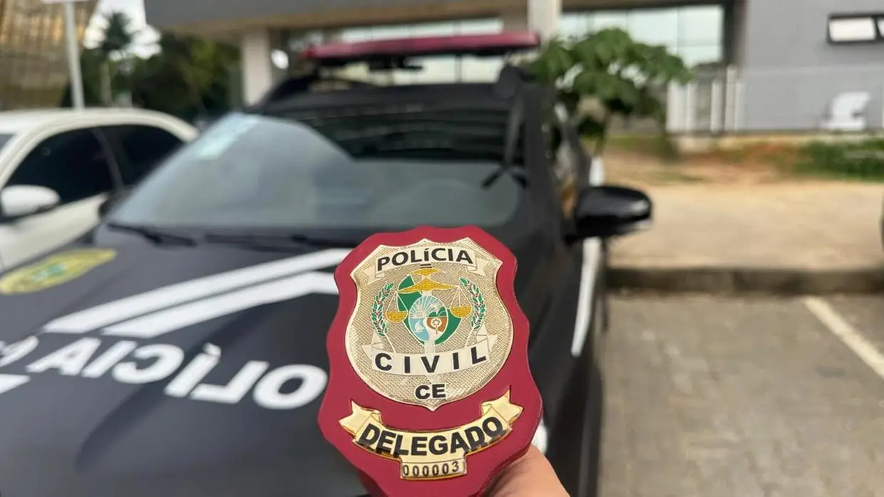 Distintivo de delegado da Polícia Civil do Ceará frente a carro da Polícia Civil do Ceará