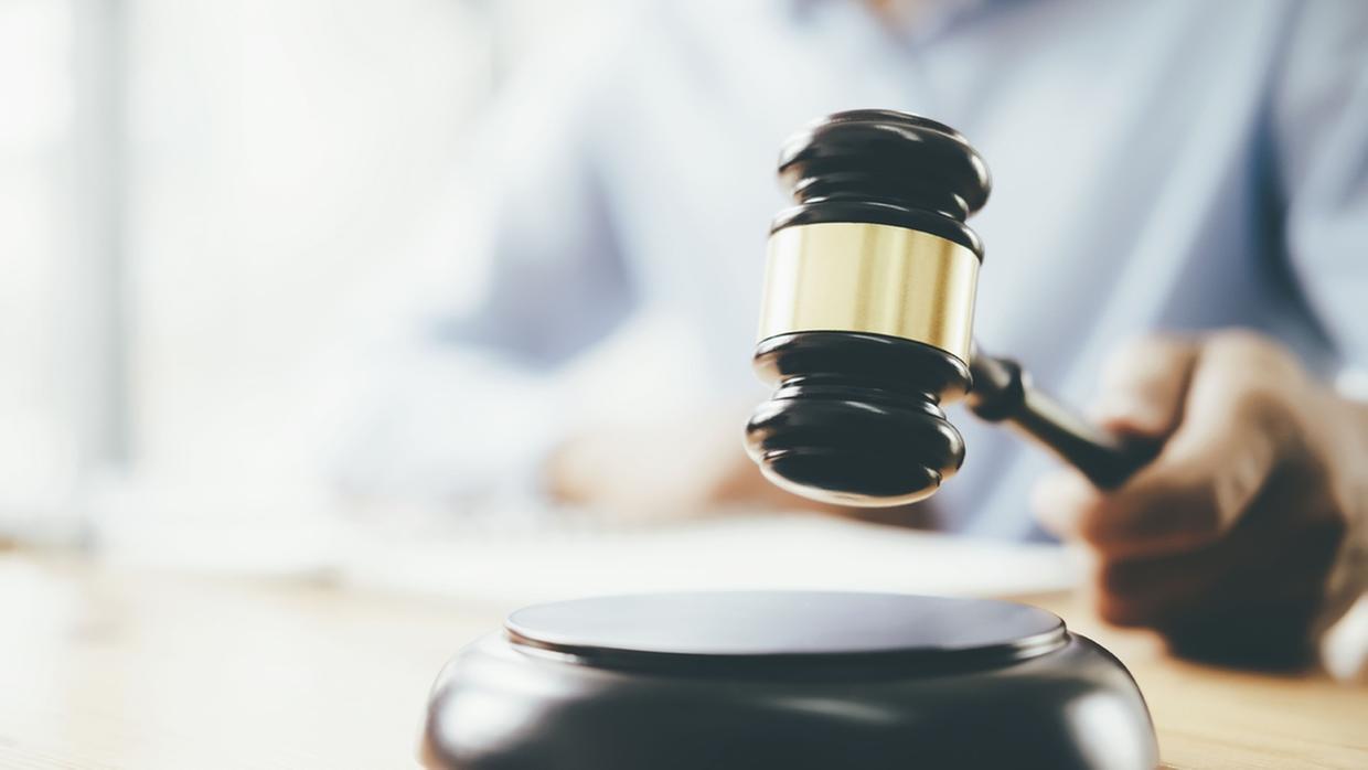 foto de juiz batendo o martelo em um tribunal, simbolizando a decisão e a justiça. O martelo é um símbolo do sistema judiciário e da lei.