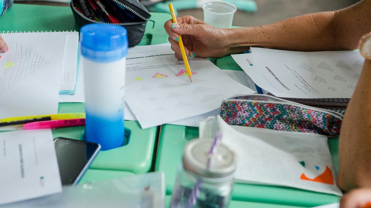 Imagem de mãos com exercícios de matemática