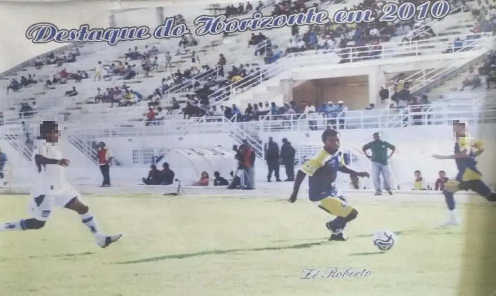 Foto antiga mostra José Roberto de Sousa Severo em atuação pela equipe Horizonte, em uma partida de futebol, em 2010. É possível ver jogadores, a bola e campo de futebol em primeiro plano, com torcedores na arquibancada ao fundo