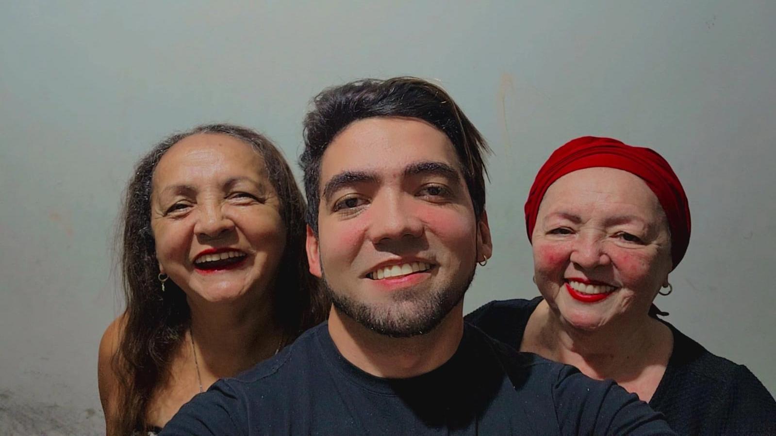 Leandro, ao centro, e as duas mães, uma de cada lado