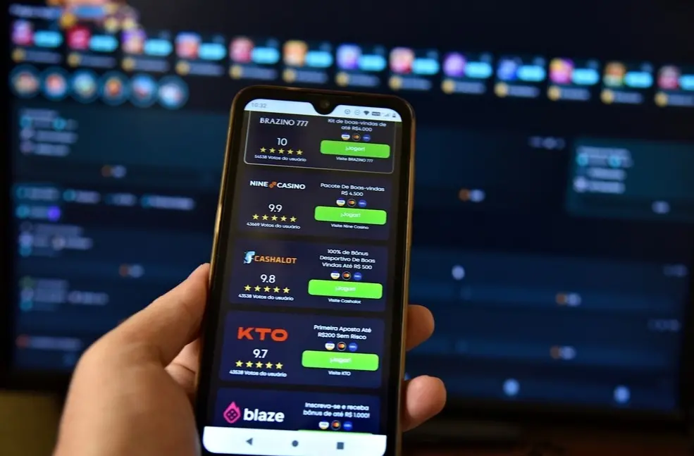 Mão segura celular aberto em plataforma de apostas online