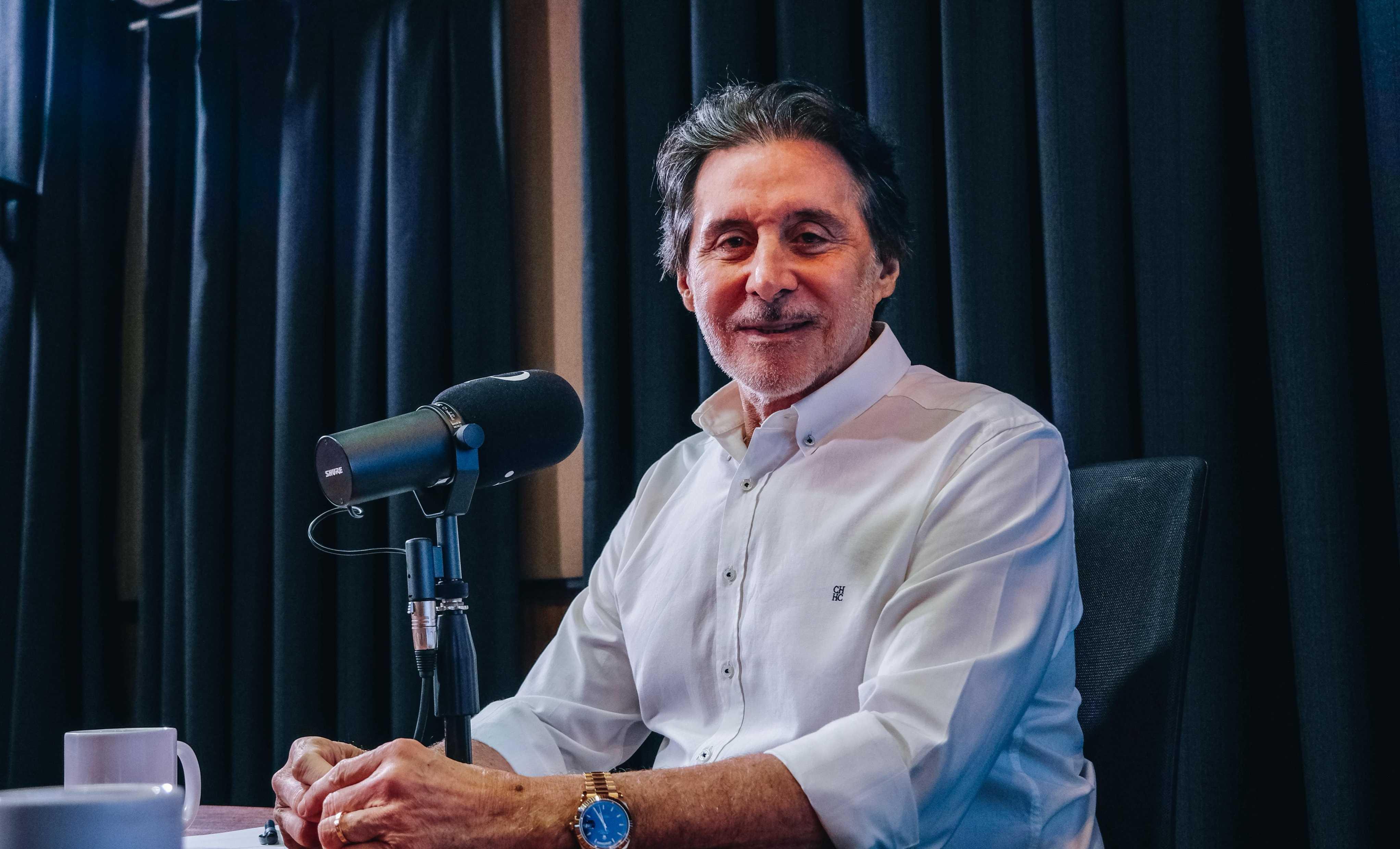 Eunicio Oliviera durante entrevista para a live do PontoPoder. Ele está sentado na mesa, diante do microfone com o simbolo do PontoPoder