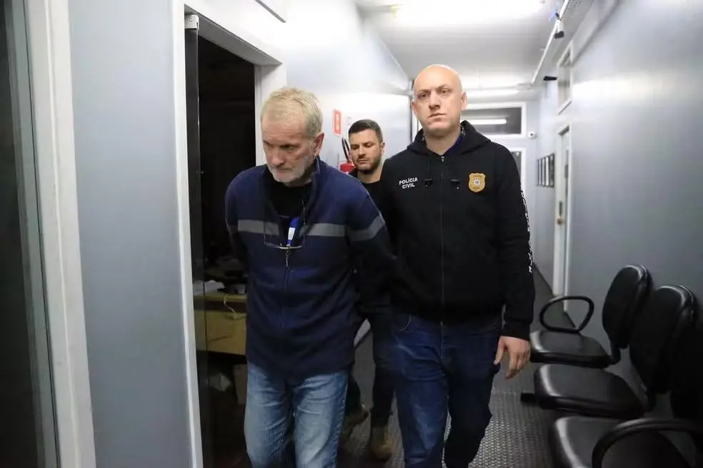 Homem detido suspeito de matar e esquartejar mulher e esconder partes do corpo em mala na rodoviária sendo preso por agente policial