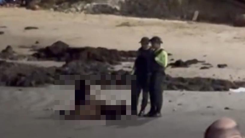 Na foto, dois policiais militares aparecem ao lado de um casal flagrado fazendo sexo na praia em Fortaleza