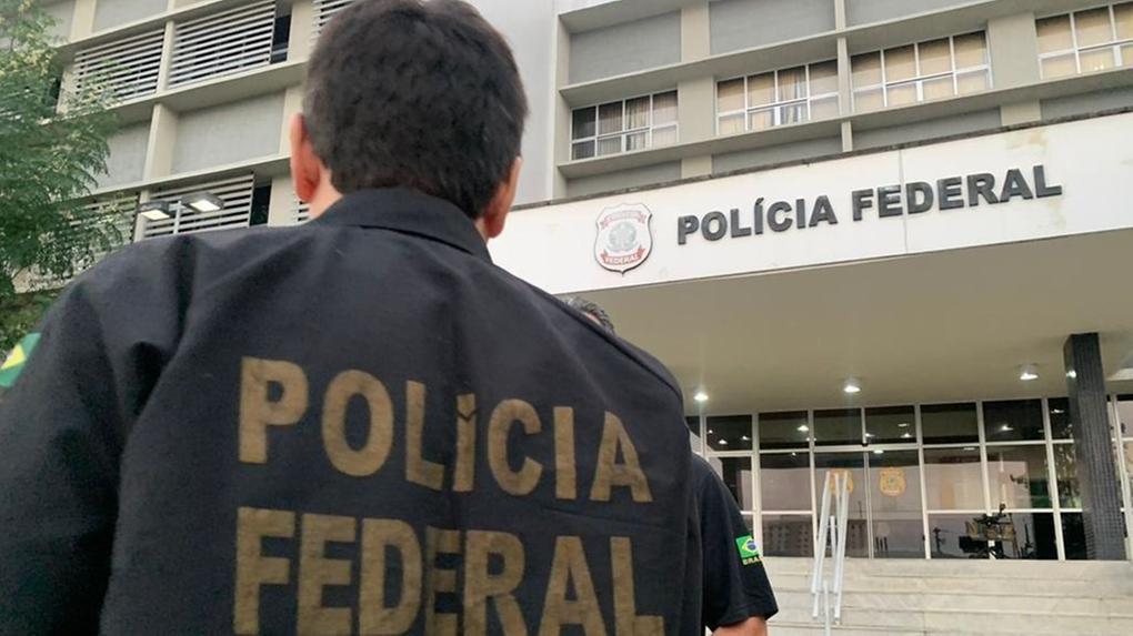 Foto mostra um policial federal, fardado, em frente à sede da Polícia Federal em Fortaleza