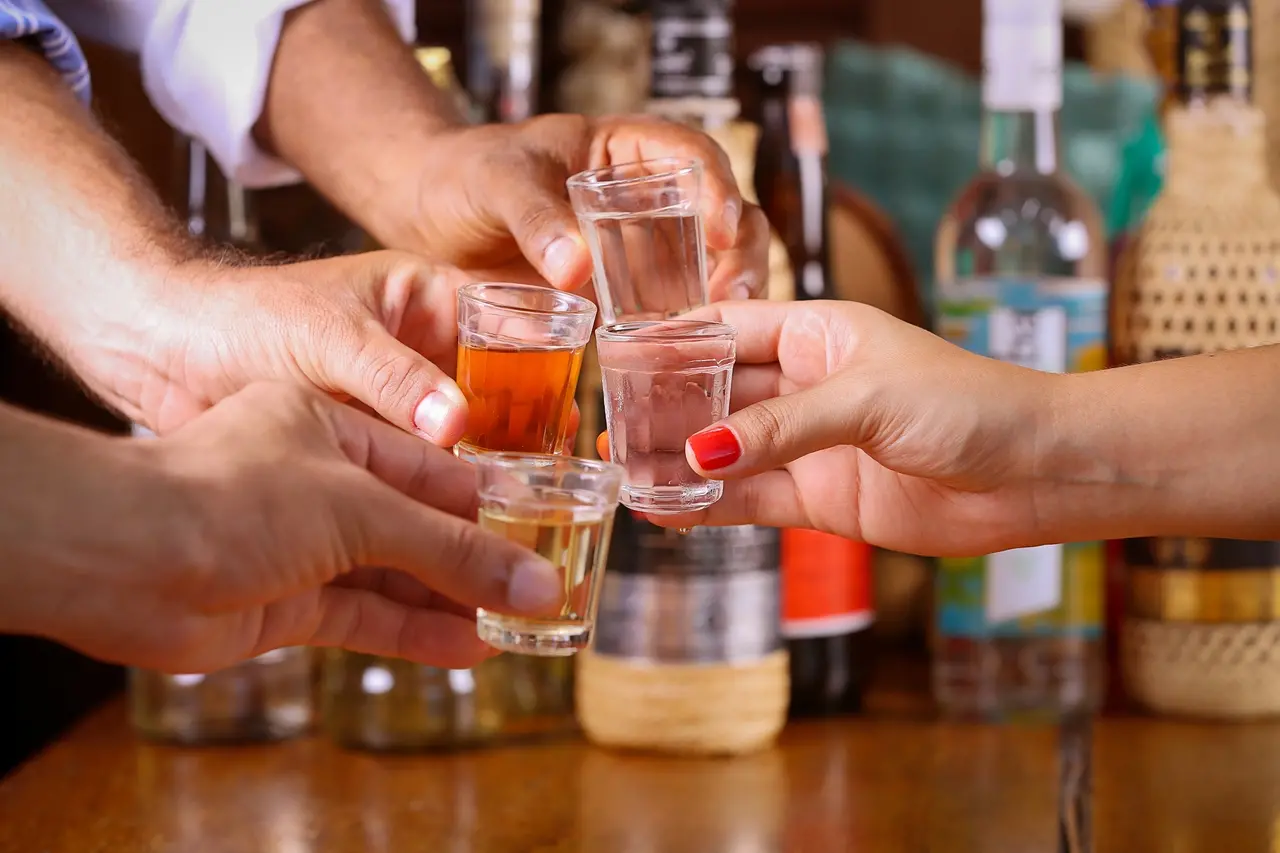 Pessoas brindando com cachaça