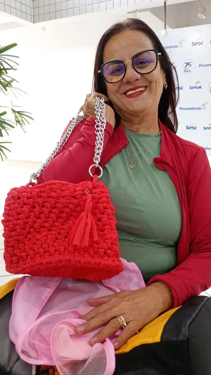 Mulher mostra peça de crochê feita por ela