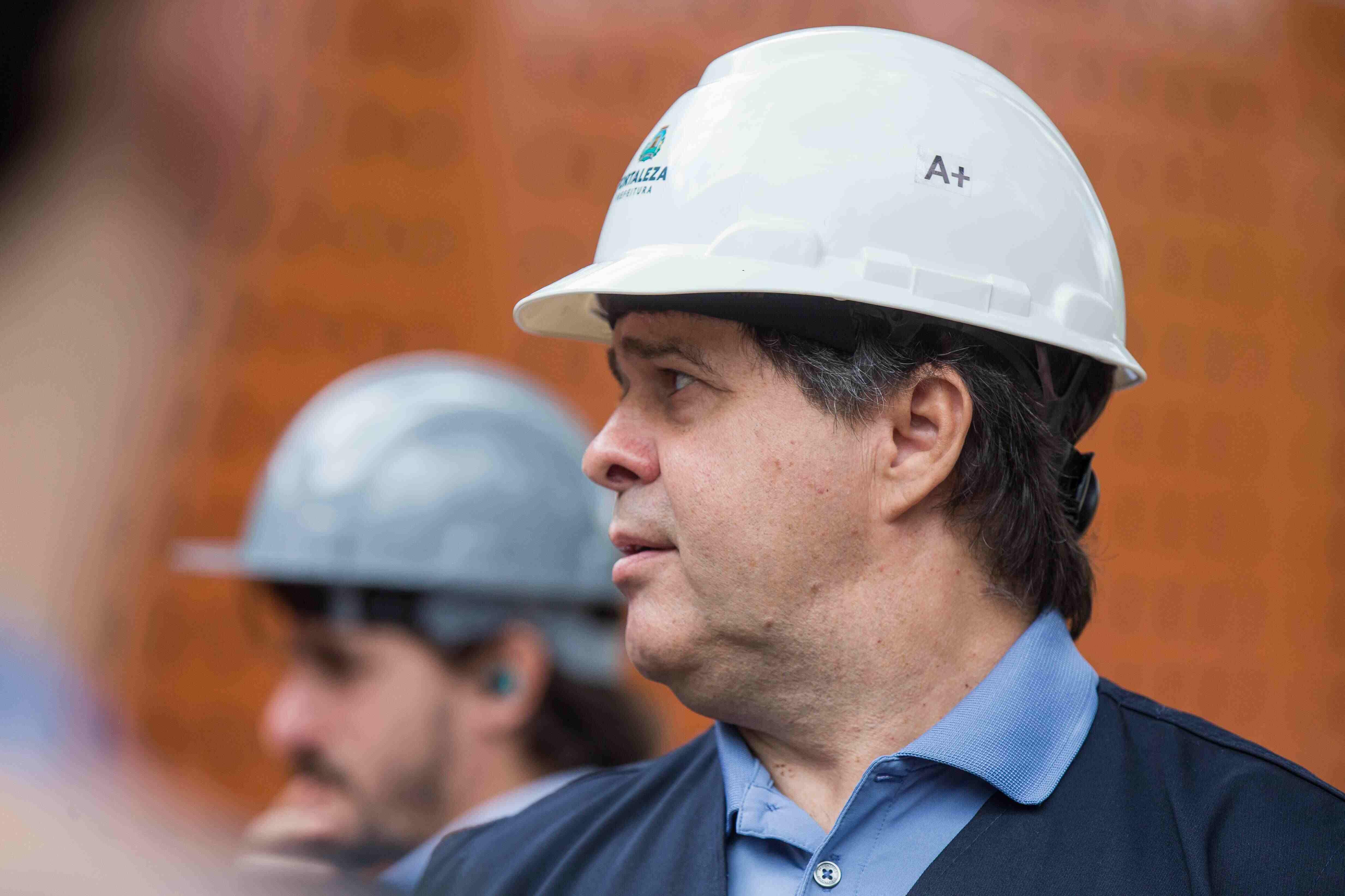Foto de Evandro Leitão, prefeito de Fortaleza, de capacete durante visita em obra do Município