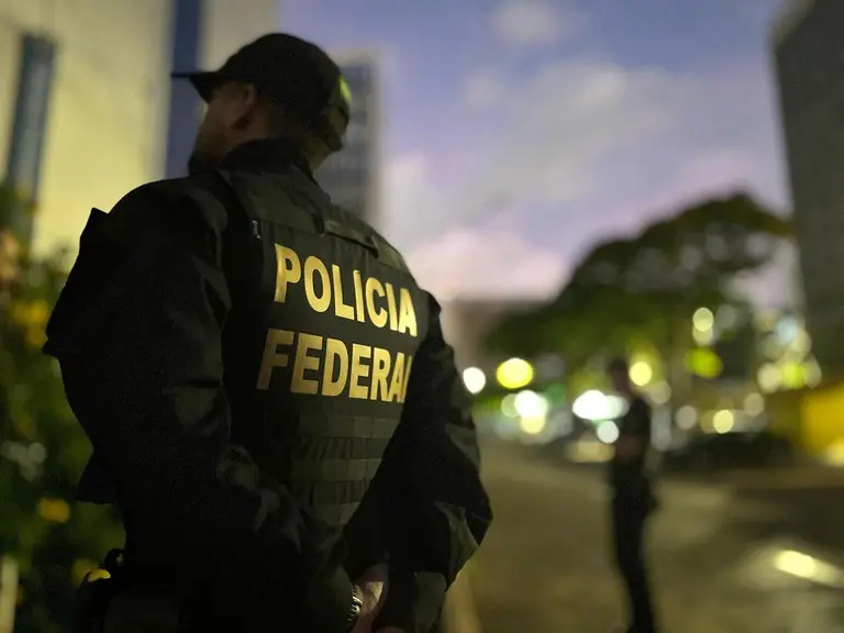 Policial federal de uniforme preto, com colete escrito 