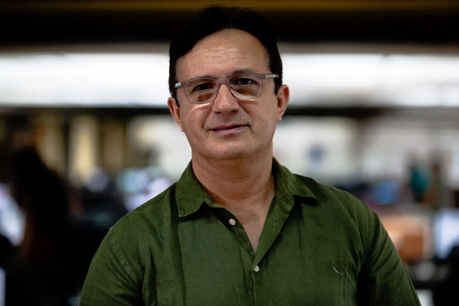 Retrato do reitor da UFC, Custódio Almeida. Ele tem cabelos pretos, usa óculos e usa uma camisa social verde escuro