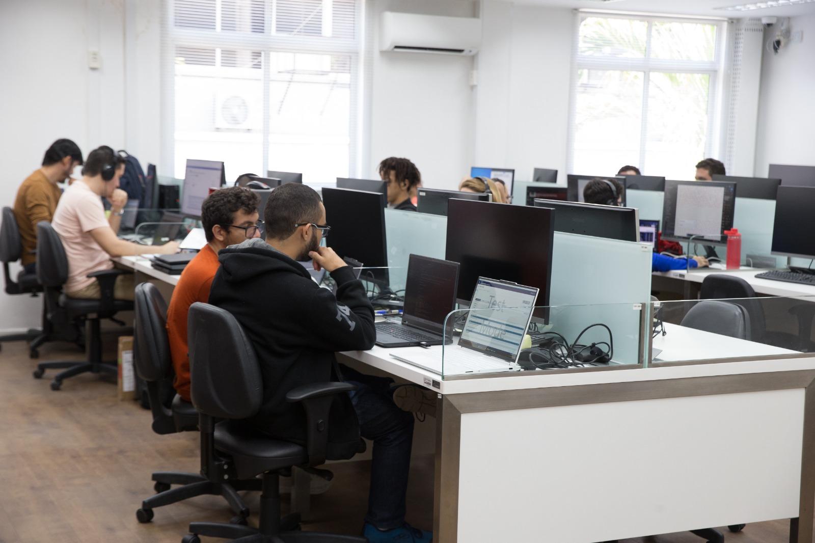 Laboratório de informática na UFC com diversos alunos digitando em computadores