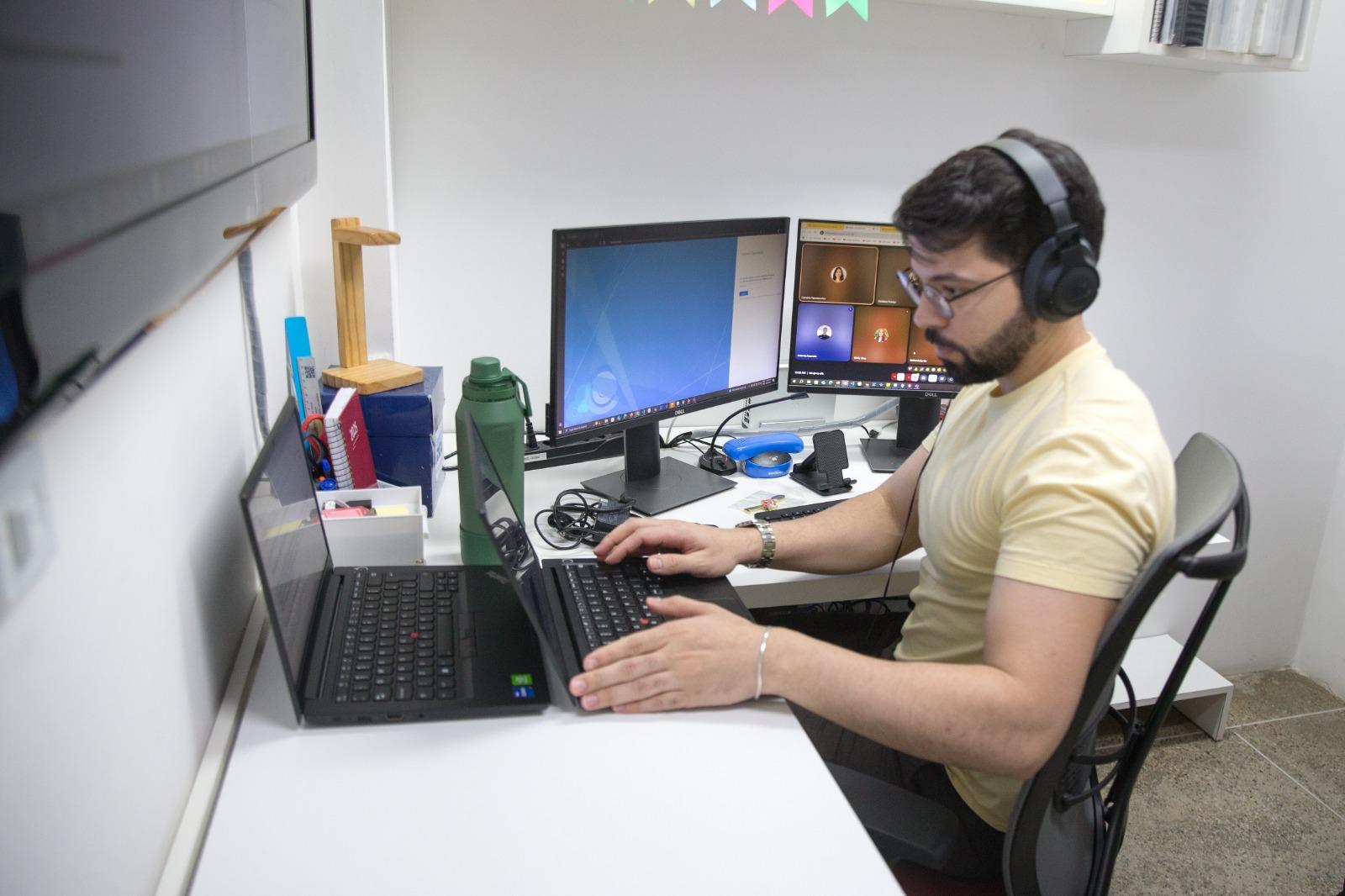 Homem de barba e headphones digita em computador na UFC