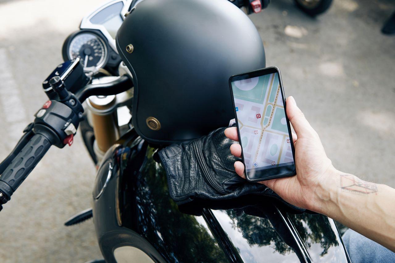 pessoa segurando celular em cima de motocicleta