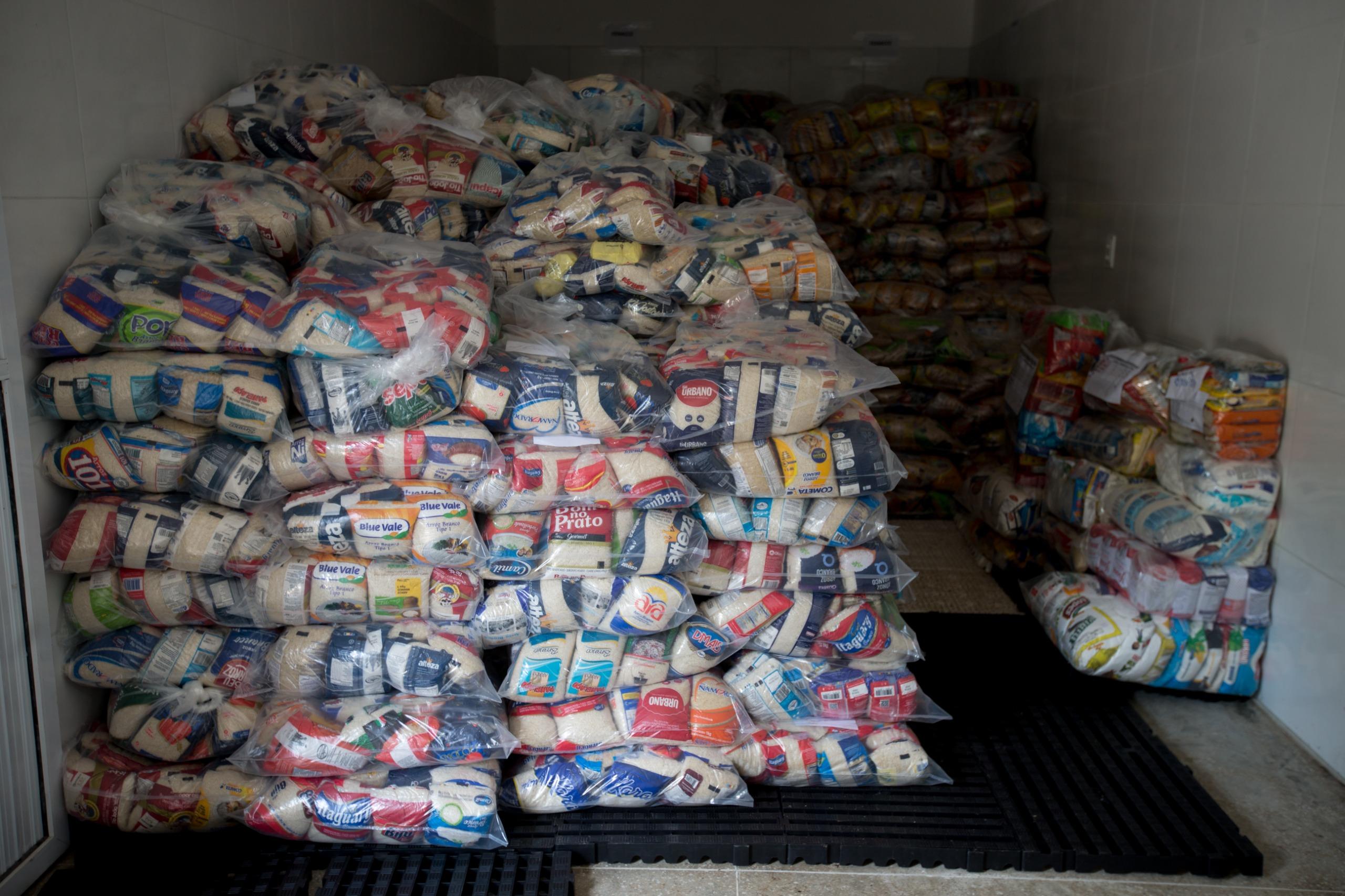 Imagem mostra uma pilha de cestas básicas dentro do baú de um caminhão.