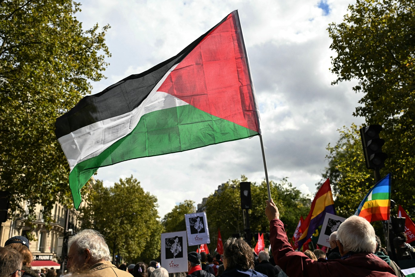 Foto que contém manifestação com francês empunhando a bandeira da Palestina