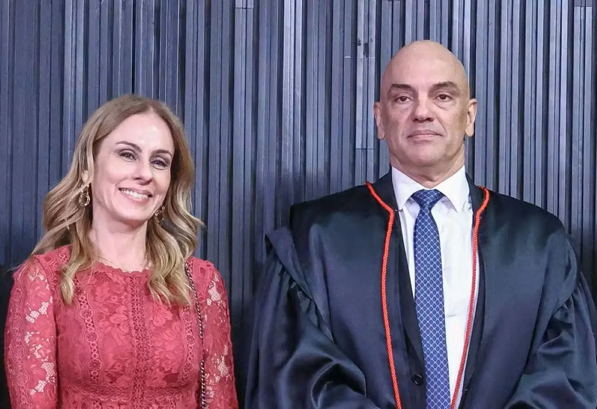 Viviane Barci de Moraes ao lado de Alexandre de Moraes, ambos sorrindo, em evento formal; ela veste um vestido rendado vermelho e ele está com toga e gravata.