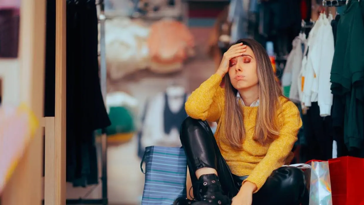 Mulher está sentada e pensativa.