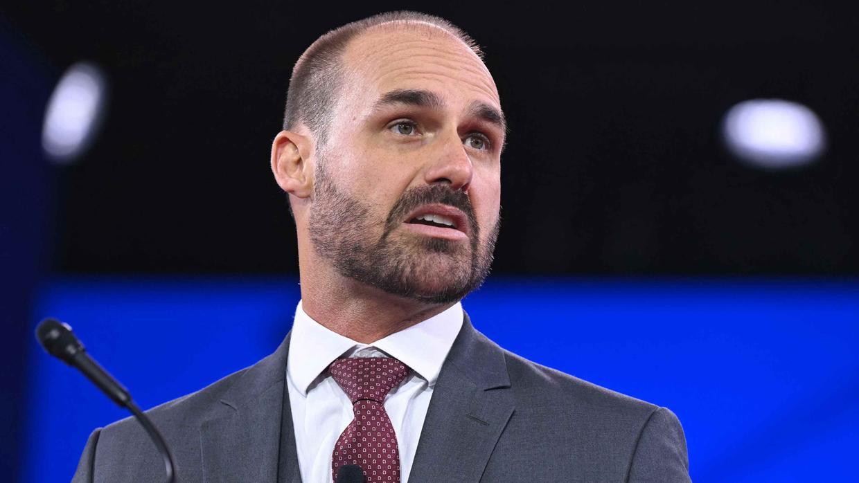 Eduardo Bolsonaro está ao lado de um microfone