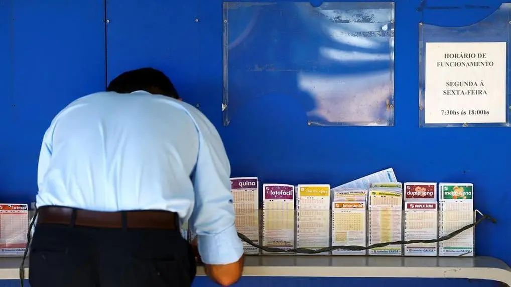 Senhor realizando apostas em uma lotérica.