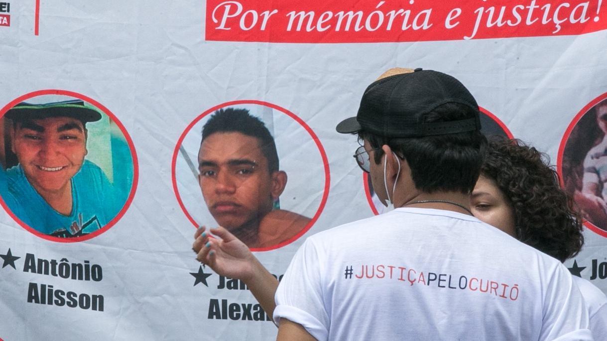 Imagem da faixa com os rostos das vítimas da chacina do Curió usada em matéria sobre julgamento do caso que condenou PMs (policiais militares) no Fórum do Tribunal de Justiça do Ceará