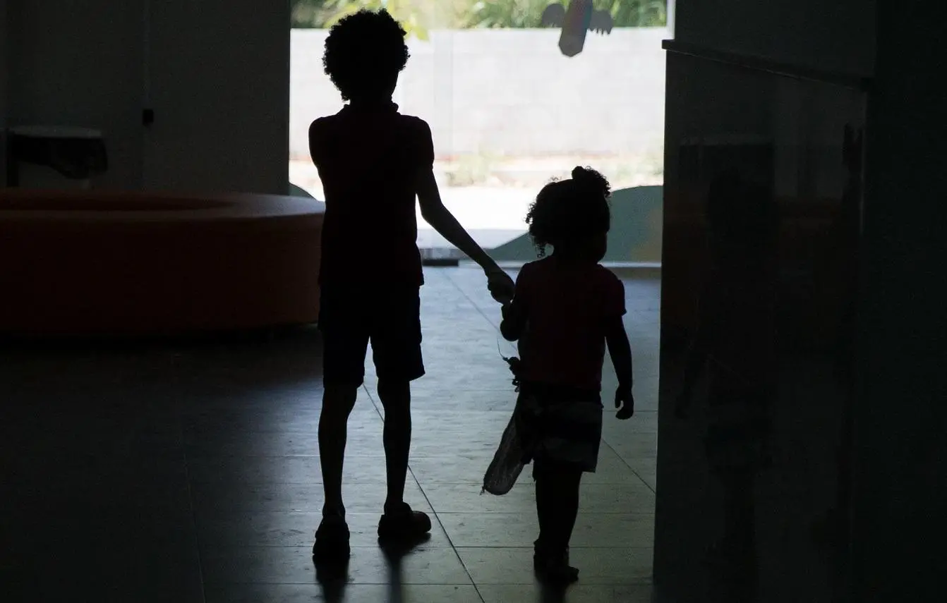 Foto mostra silhueta de crianças caminhando