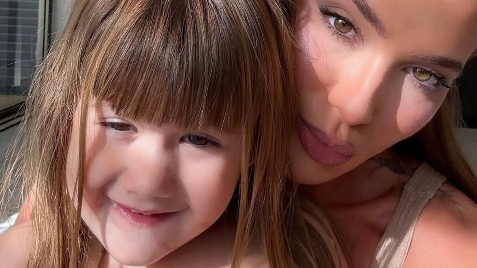 Imagem mostra Maria Alice, filha de Virginia, sentada no colo da mãe