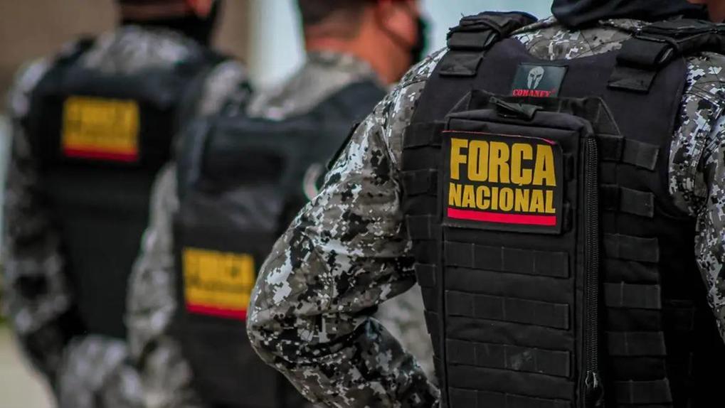 Policiais da Força Nacional usam uniformes camuflados em tons de cinza e coletes pretos com a identificação
