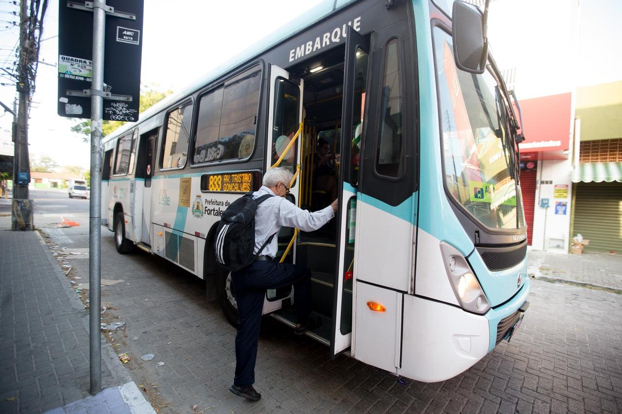Homem idoso subindo em um ônibus.