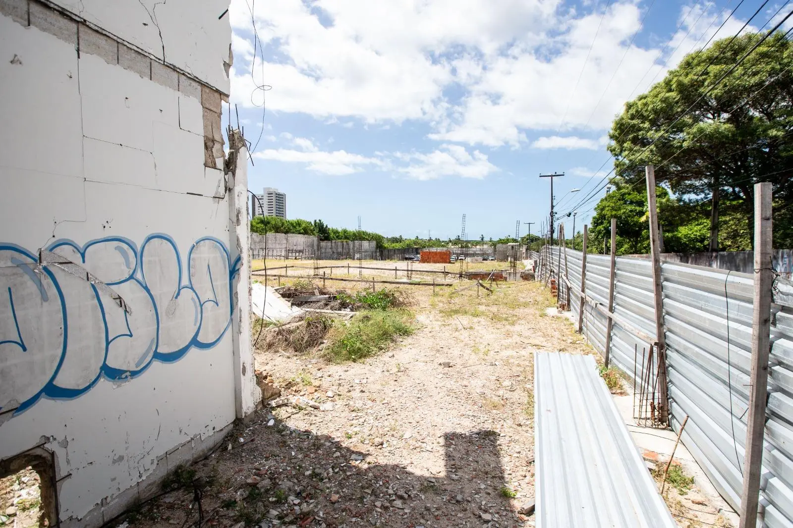 Imagem de terreno vazio, cercado por tapumes metálicos