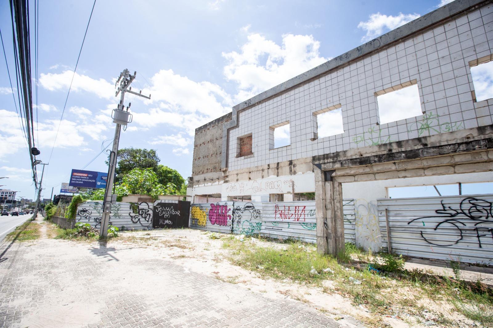 Fachada de terreno abandonado, com fachada branca deteriorada