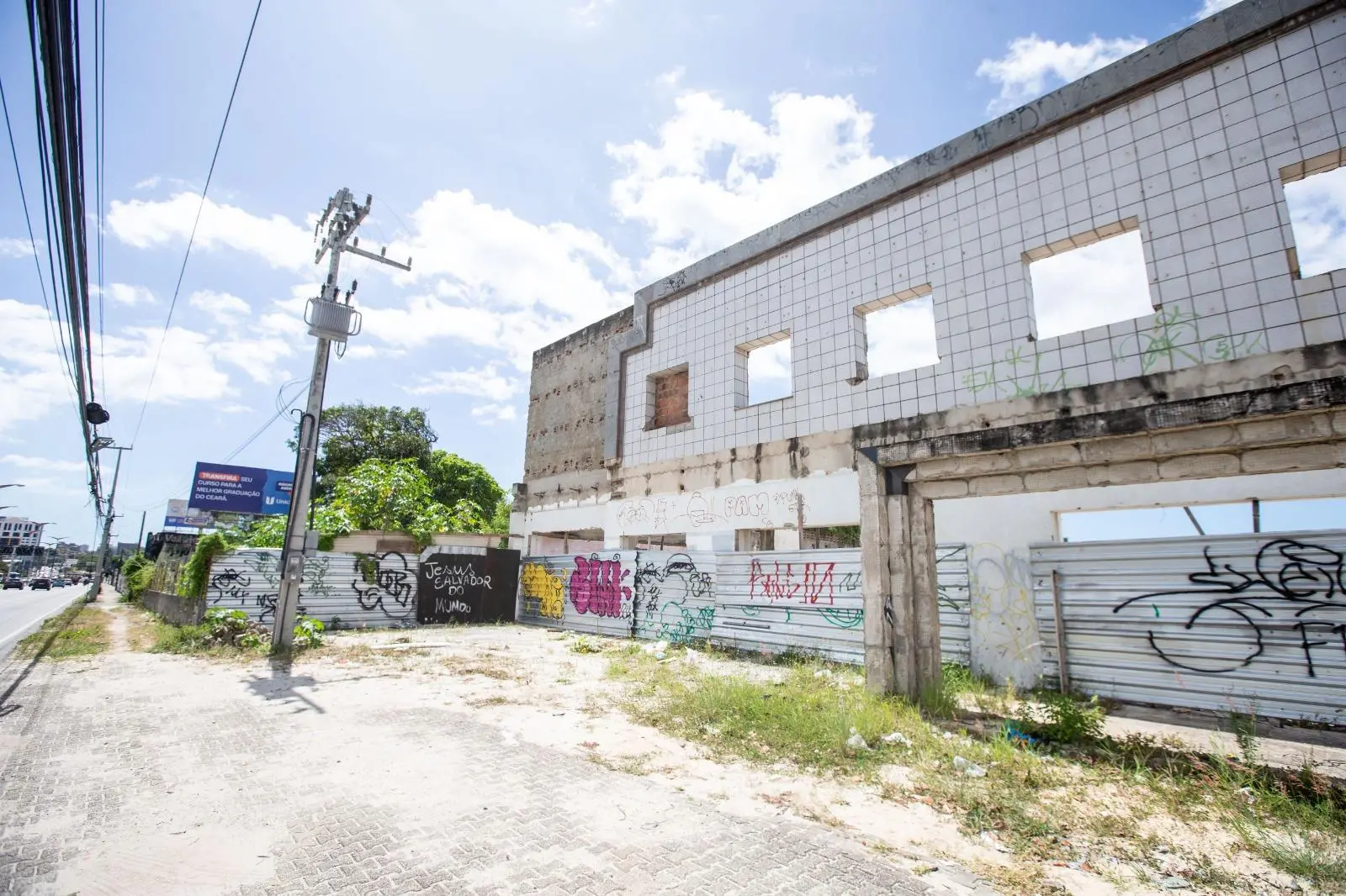 Fachada de terreno abandonado, com fachada branca deteriorada