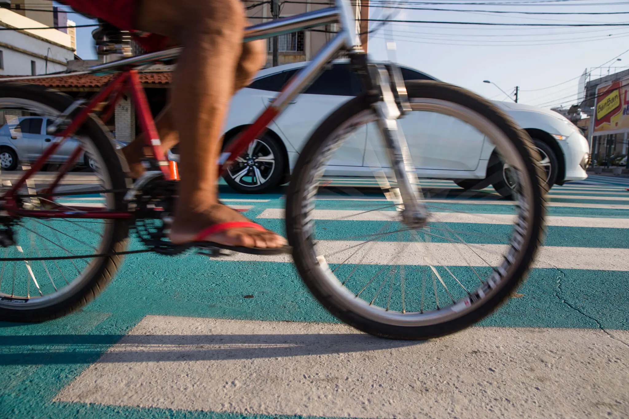 Detalhe das pernas de um ciclista sobre bicicleta, no trânsito de Fortaleza