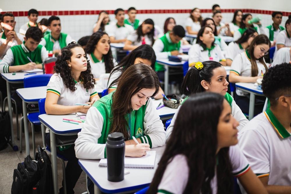 sala de aula com vários alunos sentados em carteiras estudantis