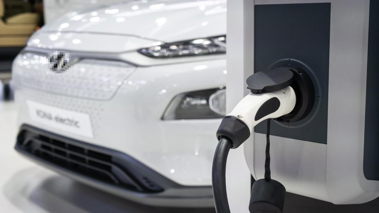 Frente de carro elétrico e tomada de carregamento.