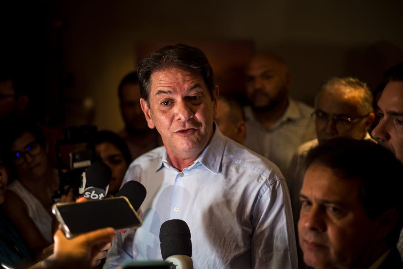 Cid Gomes durante entrevista à imprensa. Ele veste camisa azul e está ao lado de Evandro Leitão