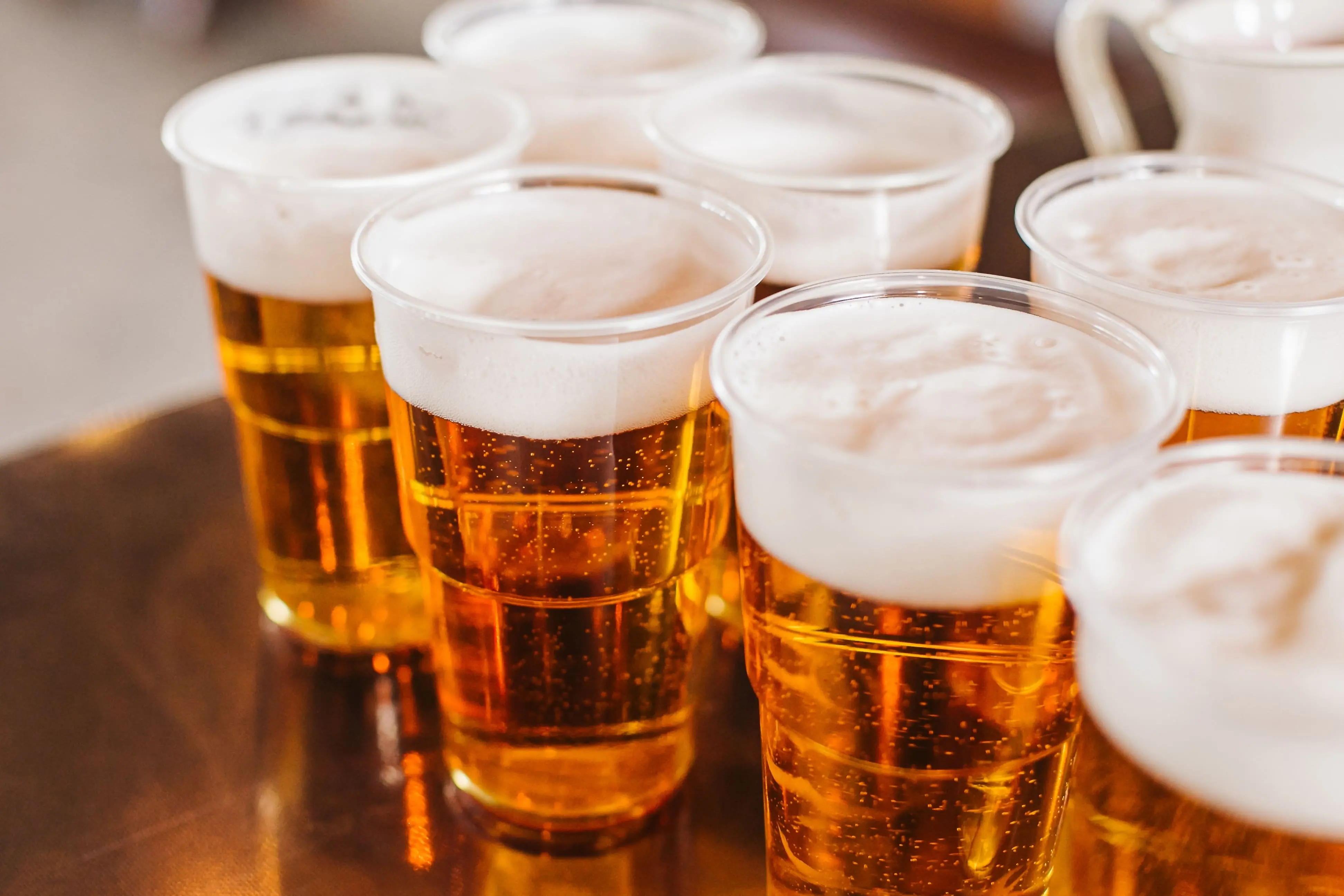 vários copos de plástico cheios de cerveja.