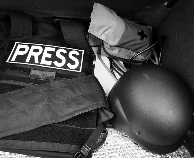 Colete e capacete usados por profisisonais da imprensa.