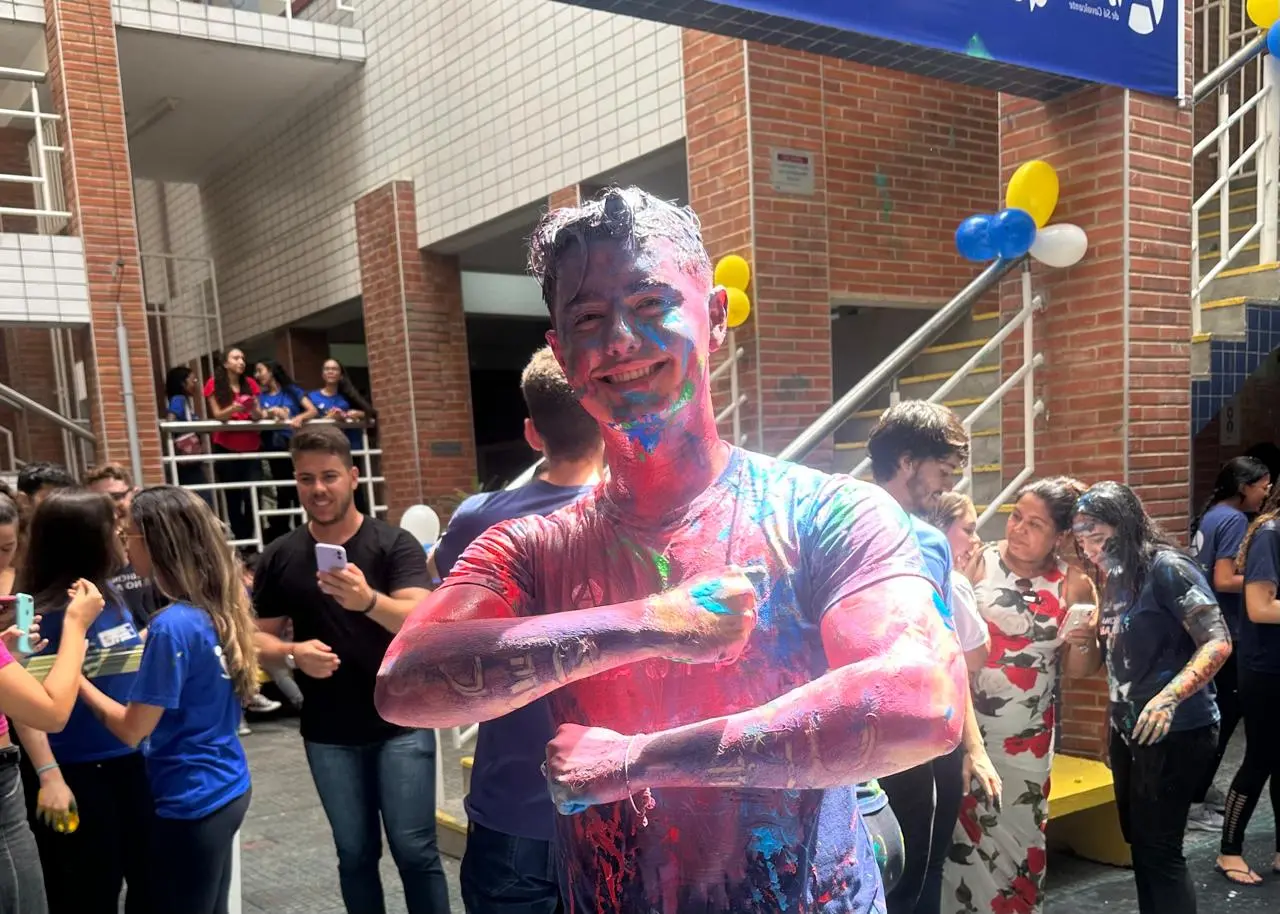 Juventude comemorando a aprovação no vestibular com diversão e alegria na celebração ao ar livre.